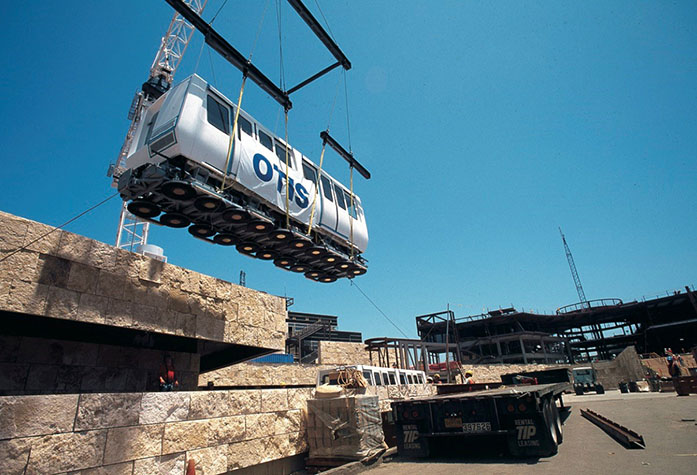 A crane lowers a tram onto the tracks during the construction of the Getty Center in late 1994.