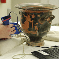Conservator using an XRF unit to study the Mixing Vessel with 