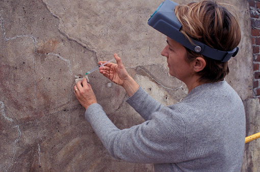 conservators examining mural