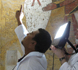 Conservators examining wall paintings