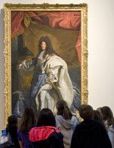 Students examine a portrait of King Louis XIV of France.