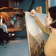 Karen Barbosa, from Brazil, cleaning a painting by William Sonntag at the Los Angeles County Museum of Art