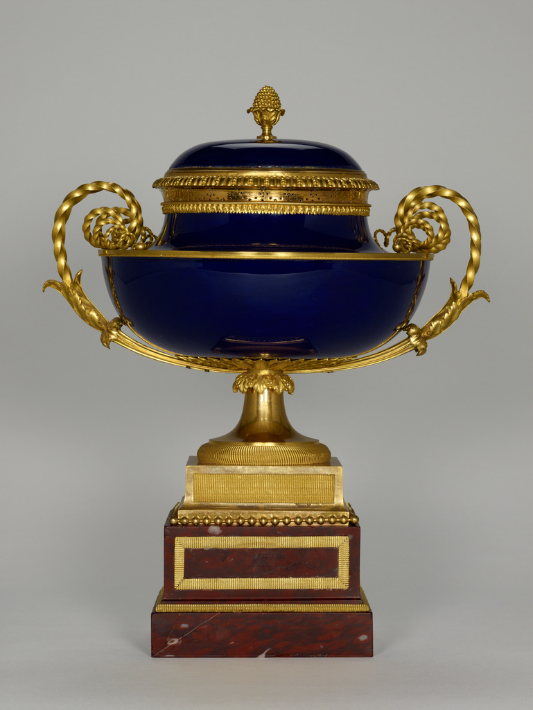 Lidded Bowl (vase cassolette); Mounts attributed to Pierre-Philippe Thomire (French, 1751 - 1843, master 1772), Sèvres Manufactory (French, founded 1756); about 1785; Hard-paste porcelain with a bleu nouveau ground color and gilt bronze mounts; rouge griotte marble; 37.5 × 34.3 × 26 cm (14 3/4 × 13 1/2 × 10 1/4 in.); 73.DI.77.1; Rights Statement: No Copyright - United States Lidded Bowl (vase cassolette); Mounts attributed to Pierre-Philippe Thomire (French, 1751 - 1843, master 1772), Sèvres Manufactory (French, founded 1756); about 1785; Hard-paste porcelain with a bleu nouveau ground color and gilt bronze mounts; rouge griotte marble; 37.5 × 34.3 × 26 cm (14 3/4 × 13 1/2 × 10 1/4 in.); 73.DI.77.1; Rights Statement: No Copyright - United States
