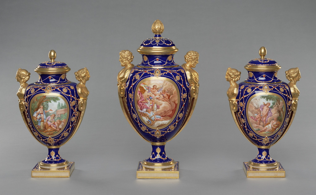 Garniture of Three Vases (vases des âges: vase des âges à têtes de vieillards, première grandeur; vases des âges à têtes de jeunes femmes, deuxième grandeur); Shape designed by Jacques-François Deparis (French, active 1746 - 1797), at least one vase modelled by the répareur Etienne-Henry Bono (French, active 1754 - 1781), reserves painted by Antoine Caton (French, active 1753 - 1798), Gilded by Etienne-Henri Le Guay (French, 1719/1720 - about 1799), Enamel jeweling by Philippe Parpette (French, active 1755 - 1757, 1773 - 1806), after engravings by Jean-Baptiste Tilliard (French, 1686 - 1766), after designs by Charles Monnet (French, 1732 - after 1808), Sèvres Manufactory (French, founded 1756); 1781; Soft-paste porcelain, beau bleu ground color, polychrome enamel decoration, enamel imitating jewels, gilding, and gold foil; 84.DE.718; Rights Statement: No Copyright - United States Garniture of Three Vases (vases des âges: vase des âges à têtes de vieillards, première grandeur; vases des âges à têtes de jeunes femmes, deuxième grandeur); Shape designed by Jacques-François Deparis (French, active 1746 - 1797), at least one vase modelled by the répareur Etienne-Henry Bono (French, active 1754 - 1781), reserves painted by Antoine Caton (French, active 1753 - 1798), Gilded by Etienne-Henri Le Guay (French, 1719/1720 - about 1799), Enamel jeweling by Philippe Parpette (French, active 1755 - 1757, 1773 - 1806), after engravings by Jean-Baptiste Tilliard (French, 1686 - 1766), after designs by Charles Monnet (French, 1732 - after 1808), Sèvres Manufactory (French, founded 1756); 1781; Soft-paste porcelain, beau bleu ground color, polychrome enamel decoration, enamel imitating jewels, gilding, and gold foil; 84.DE.718; Rights Statement: No Copyright - United States