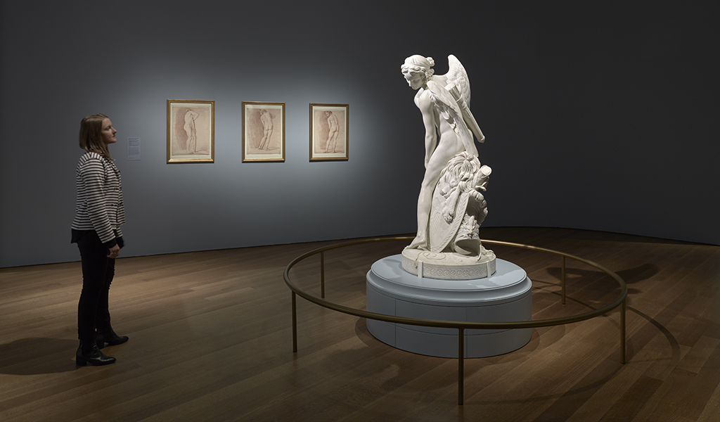 Installation view of <em>Cupid Carving a Bow from Hercules’s Club</em> (1750); in the background, preparatory drawings for <em>Cupid</em> (about 1745). All works by Edme Bouchardon, courtesy Musée du Louvre, Paris
