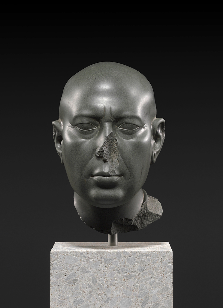 Head of a Priest, Egyptian or Ptolemaic, 400–300 BC, graywacke. Staatliche Museen zu Berlin, Ägyptisches Museum und Papyrussamlung. Photo: bpk: Bildagentur / Ägyptisches Museum und Papyrussamlung, Staatliche Museen zu Berlin – Preußischercher Kulturbesitz / Sandra Steiss / Art Resource, NY