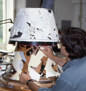 Conservator Jeff Maish places fragments into the facsimile and refers to a paper form with tracings of the original fragments