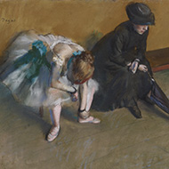A simple image: two women seated on a bench in a bare room.