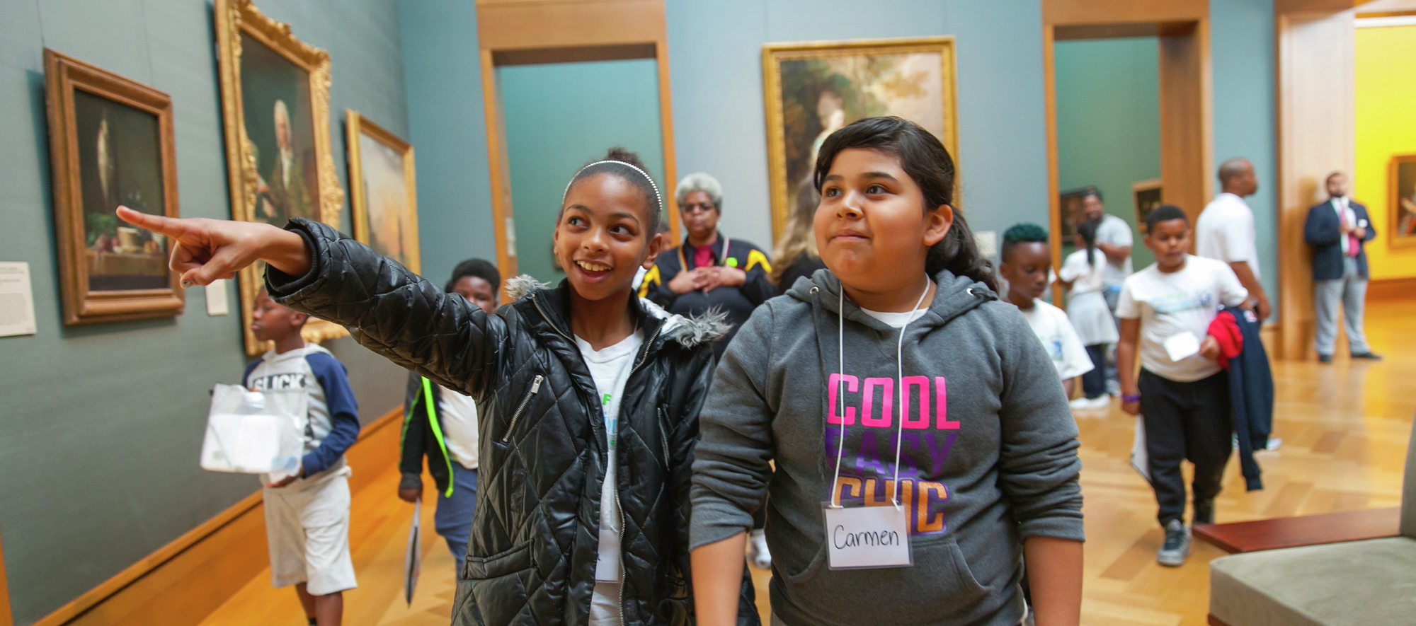 Two children walking through an art gallery