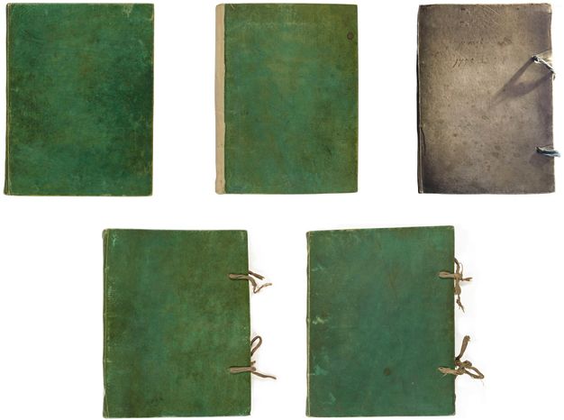 Photograph of five bound notebooks arranged in two rows, three at the top and two at the bottom. The notebook at the right end of the top row has a natural parchment cover. The other four feature green covers.