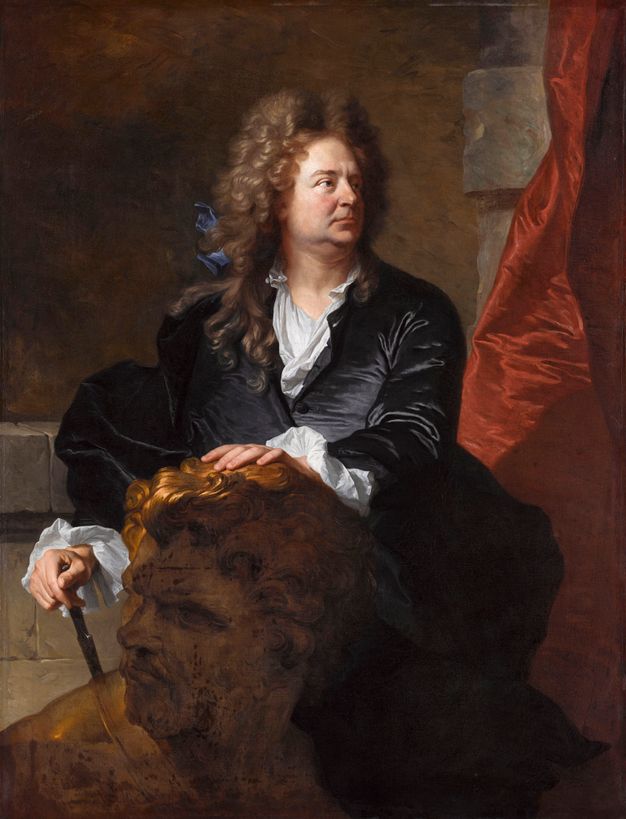 Portrait of a man half-length. He wears a long wig adorned with a blue bow and a deep blue coat. He looks towards the right, while resting his right hand on a cane and his left hand on a large, sculpted head. A bright red curtain stands out in the background.