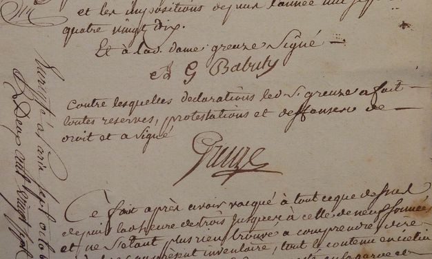 Detail of a cream-colored piece of paper showing two signatures in black ink. Text written by hand in French can be seen above, below, and between the signatures.