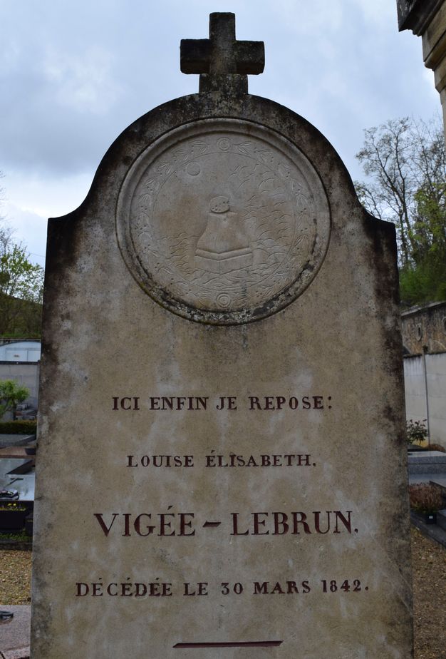 Tombstone engraved with an inscription in French filled in with red pigment. The stone features a circular medallion at the top showing a color palette on top of a plinth. The scene is surrounded by a floral garland.