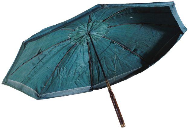Open green umbrella showing a hinged metal frame and a meal and wooden pole.