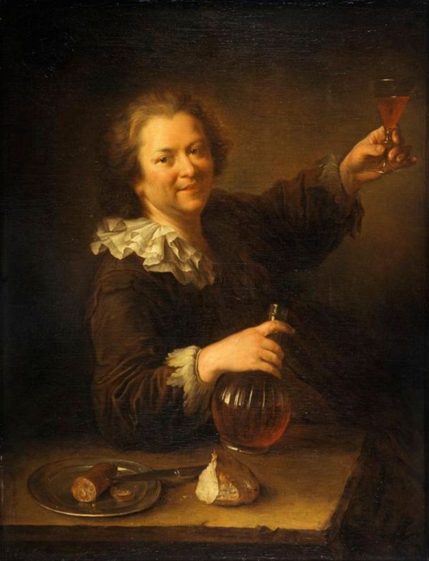 Portrait of a man raising a wine glass above his head. He wears a loose black coat with white ruffles around the collar. He is pictured grasping a fluted carafe in his right hand while resting his elbow on the table in front of him. The table holds a metal plate with a cured sausage, a knife, and some bread.