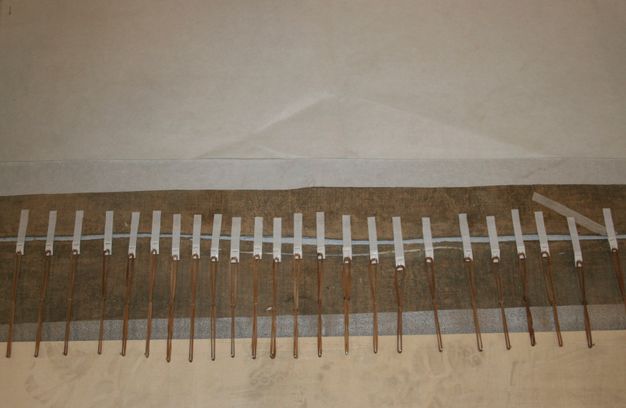 Photograph close-up of the canvas seam lined with rubber bands.