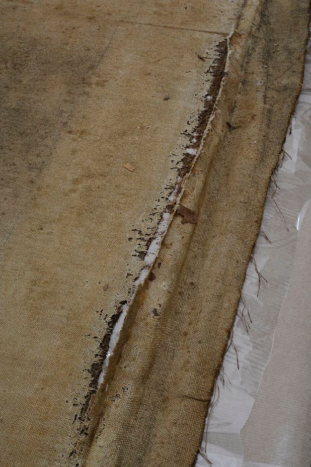 Close up photo showing canvas lining that is worn and damaged.