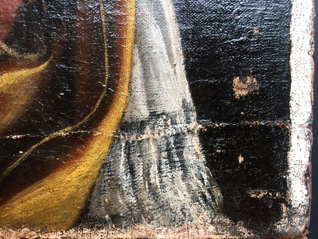 Close up photo of the portrait in 22.1. It shows the wear on the canvas.