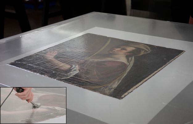 Photo of the now-treated portrait laid flat on a table.