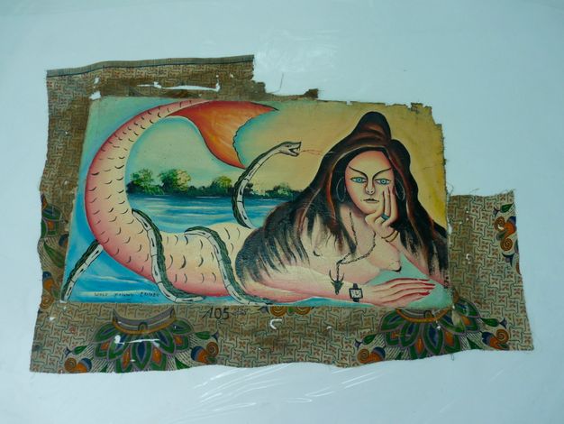 Photo of the painting (25.3) with the transparent lining atop a white surface. The colors are more vivid and the fabric is stretched.