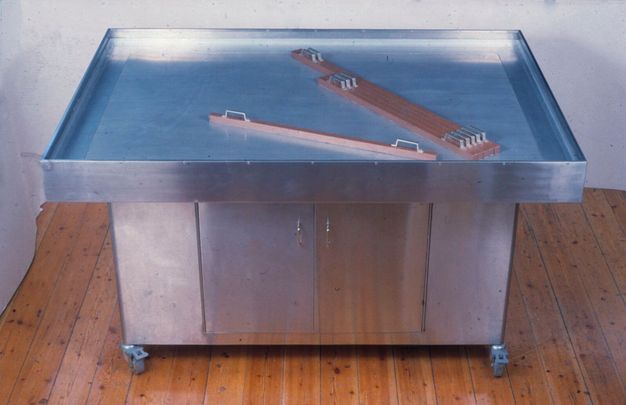 Photo of a metal table with a blue, glassy top.