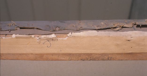 Close-up photo of the worn lining of a painting canvas.