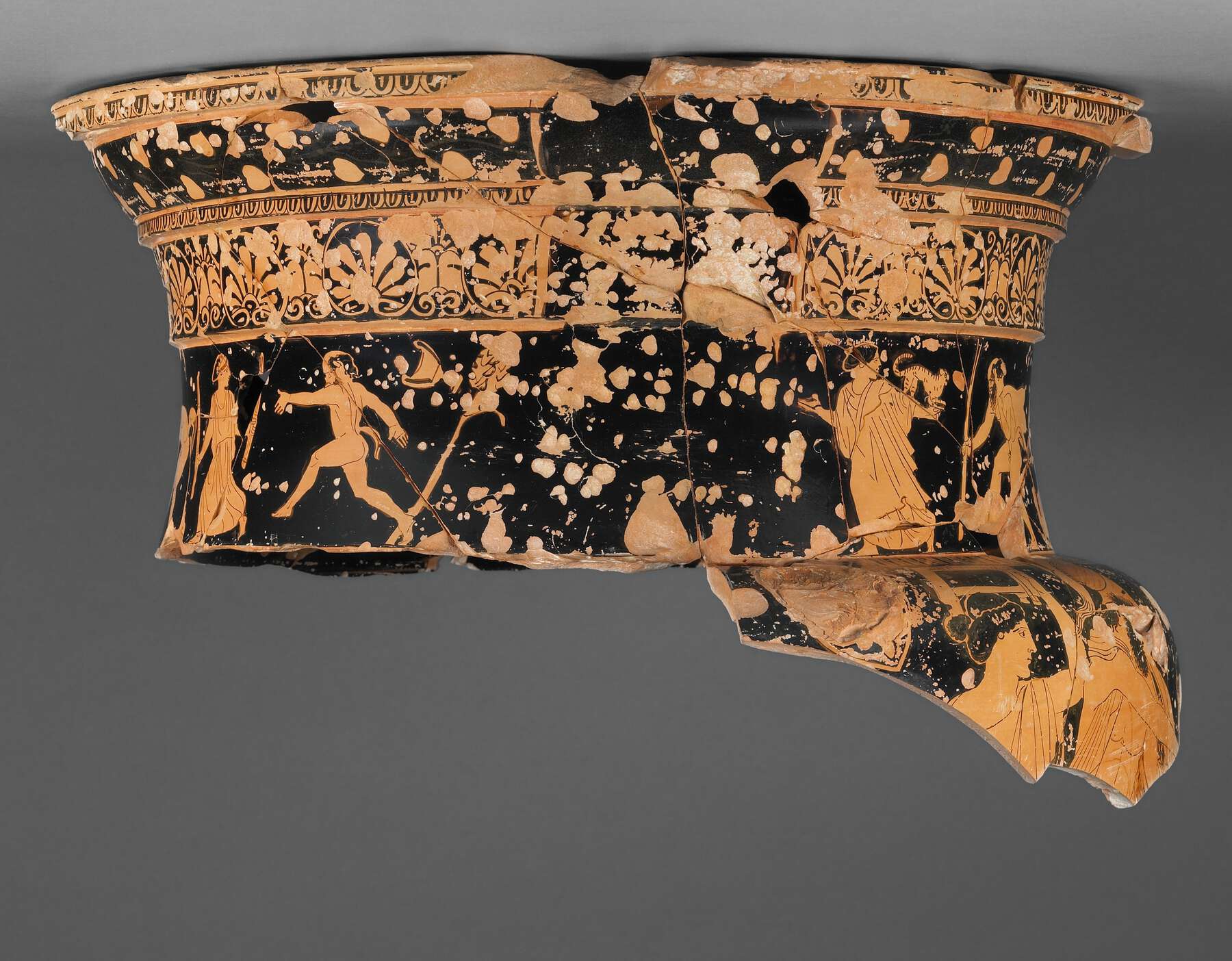 Another view of the top portion of the broken vase, showing where a handle looks like it broke off, showing more people and patterns