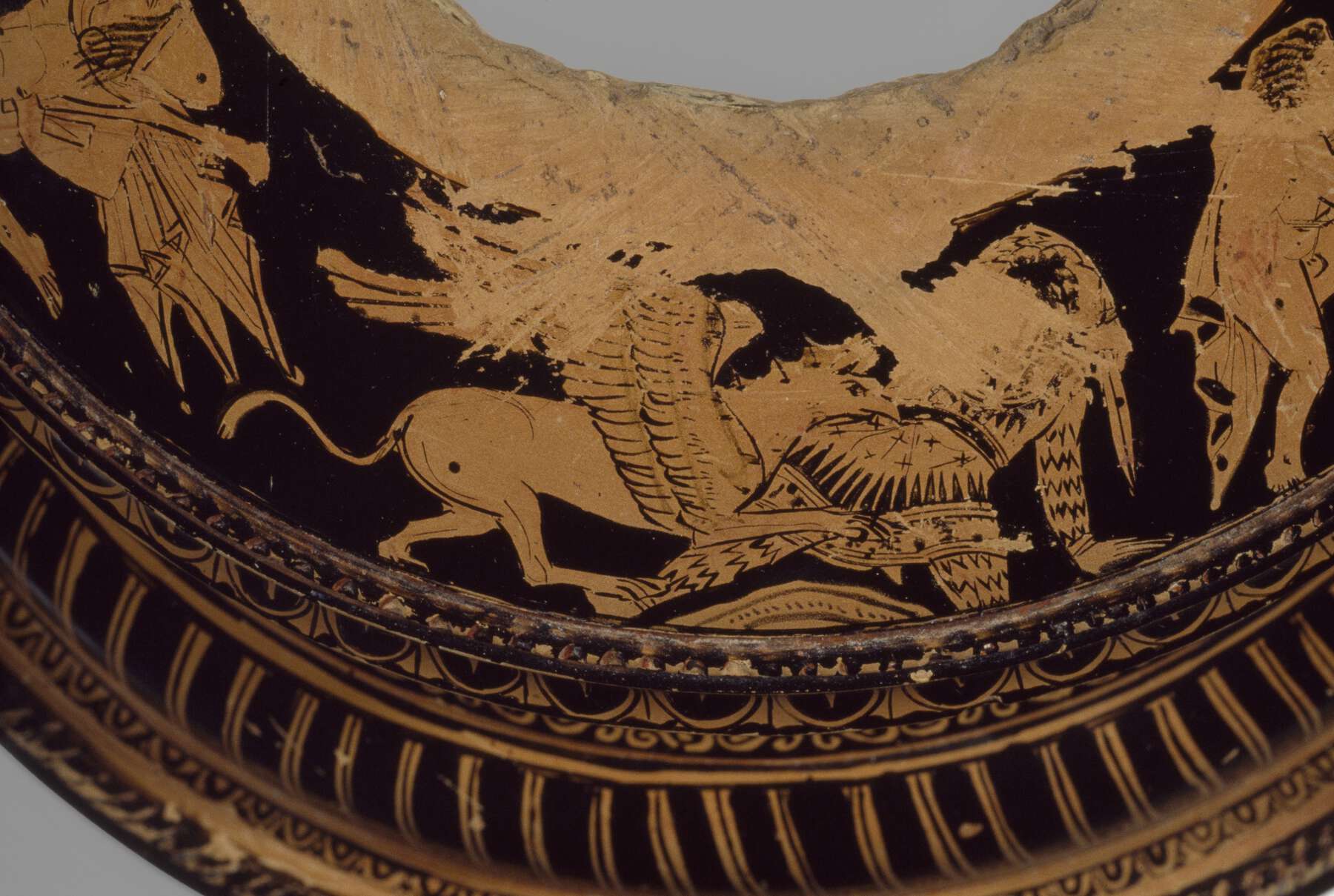 Another detail of the top of the foot, showing what looks like a griffin with its head lunging toward a person on the ground