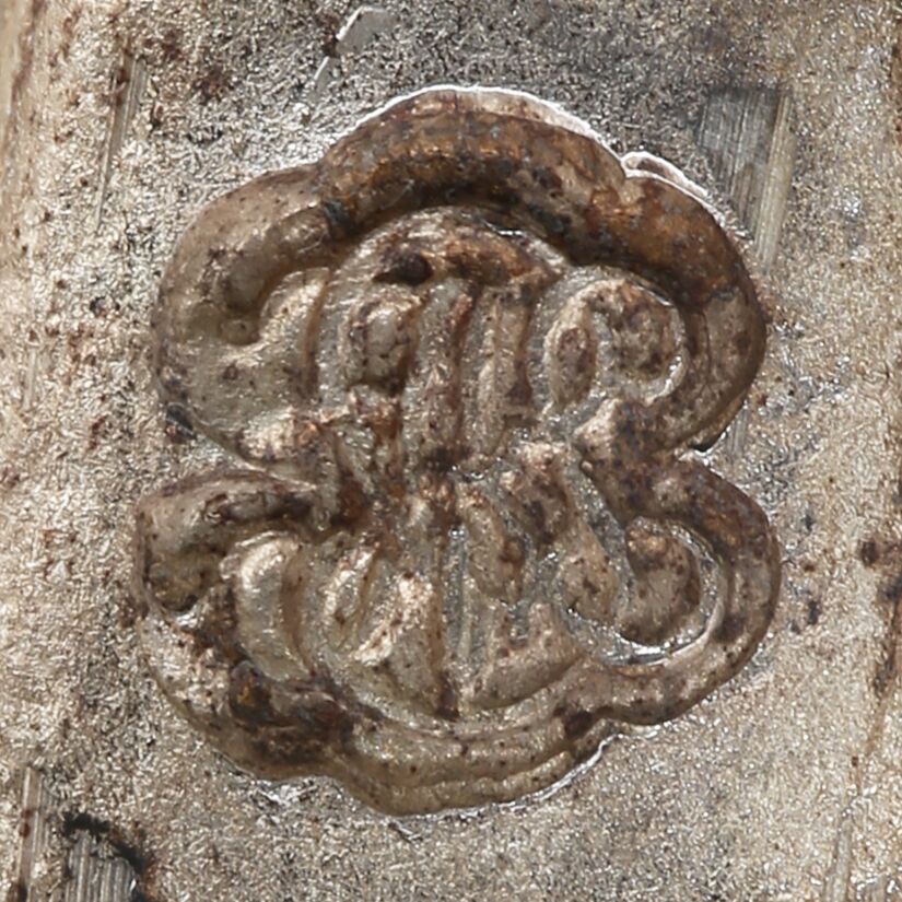 Close-up of a monagram of the letters P A R I S stylized into a flower shaped design stamped on the girandole.