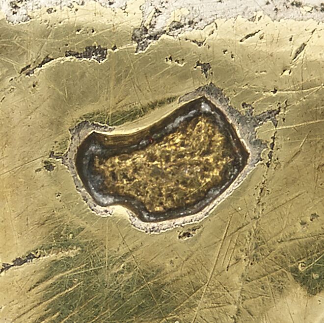Close-up of a boar head stamped on the bowl's handle.