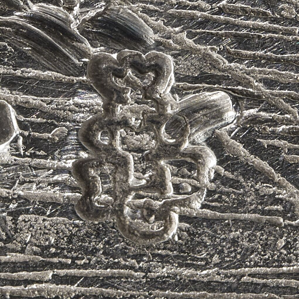 Close-up of the letters JBC in an entwined design and attached on the sauceboat.