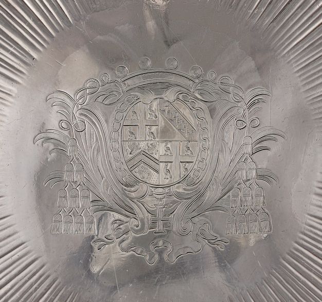 Close-up of an archbishop's coat of arms framed by palm fronts engraved on the stand.