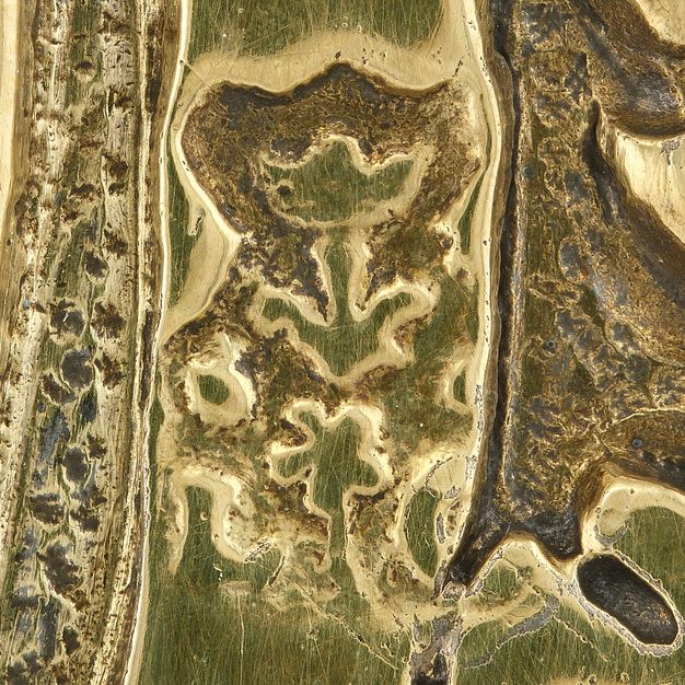 Close-up of the initials LC topped with a flower and stamped on a broth bowl.