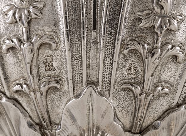 Detail of silver vessel with the letters R and I.L.R. framed by two laurel branches.