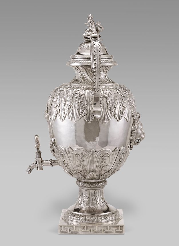 Profile view of a heavily ornamented silver vessel with a spout.
