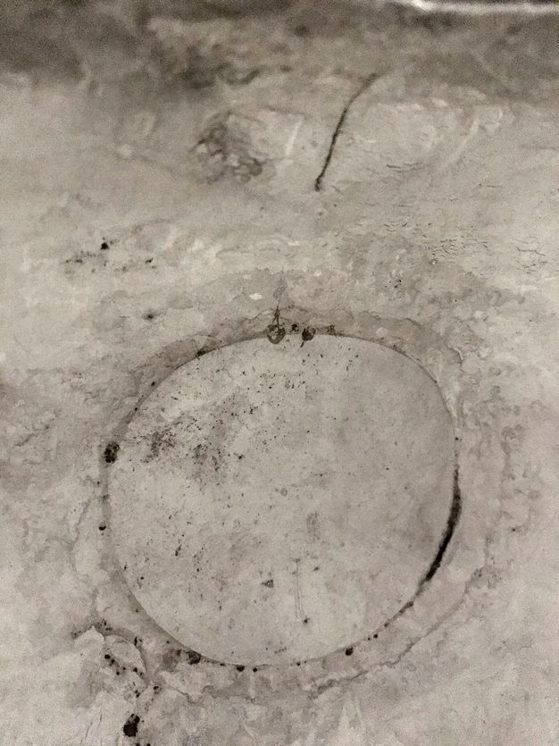 Close-up of a silver vessel's textured interior with a circular indent.