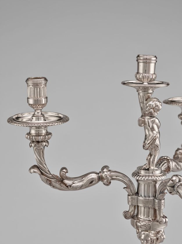 Close-up of a branch wrapped in branches and curved to hold a drip pan and candle cup.