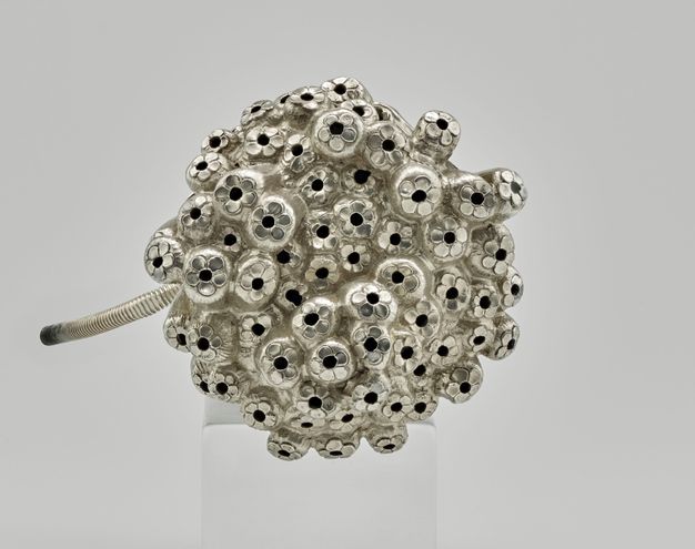 Top view of around 50 sugarcane stalks with an engraved five-petal flower and hole on top of each stalk.