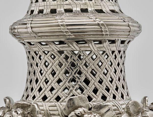 Detail view of the bottom woven basket on the silver sugar caster.