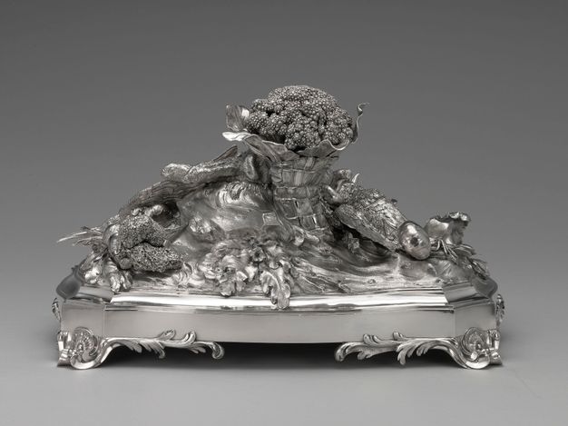 Back view of the centerpiece, revealing a large cauliflower wrapped in paper, mushrooms, and root vegetables.