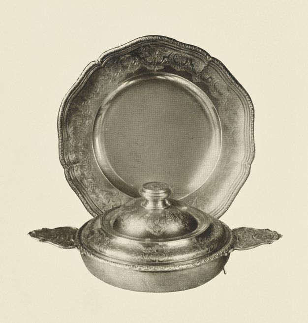 Black and white photograph of a lidded bowl in front of a circular broth bowl.