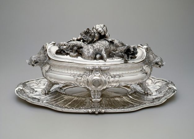 Boar-headed tureen with a lid bearing a dead rabbit, a crayfish, oysters, artichokes, leafy greens, and a mushroom.