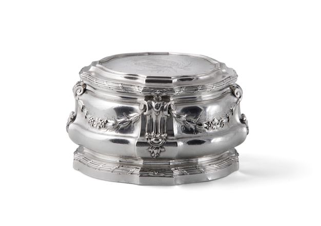 Front view of a silver lidded box with decorated by leafy garlands.