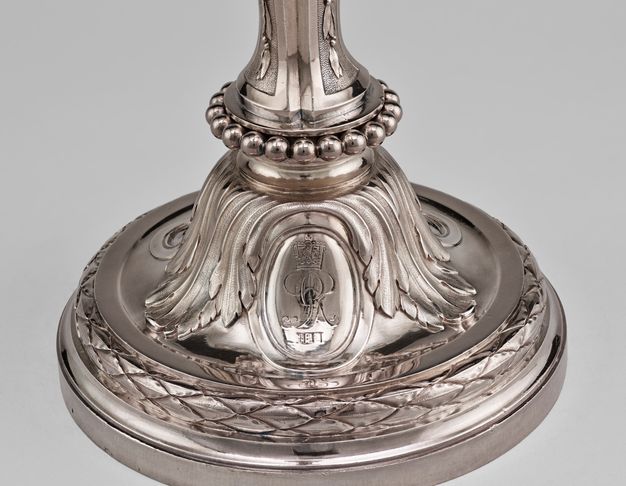 Base of the girandole with a string of spheres decorating the the top, leaves covering the sides, and an oval with a crowned GR III inside it.