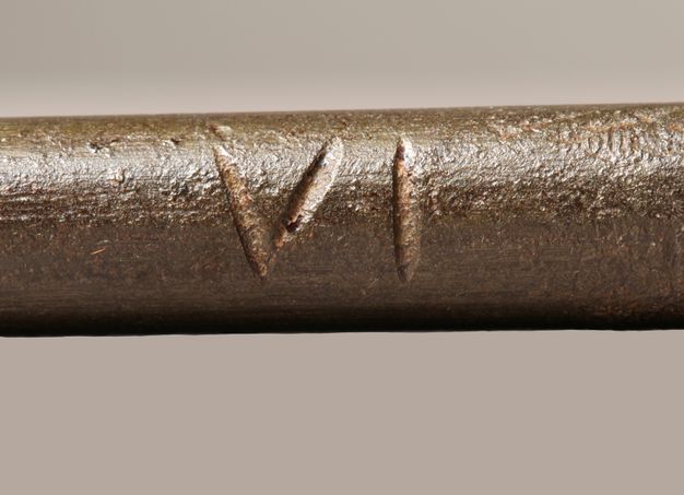 Close-up of the Roman numeral VI scratched on the girandole.