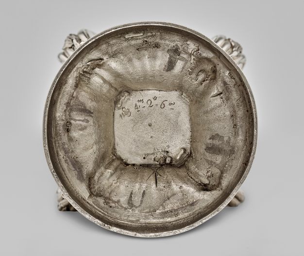 Circular base of the sugar caster with a square in the center with the caster's numeral and weight inscribed along its top edge.