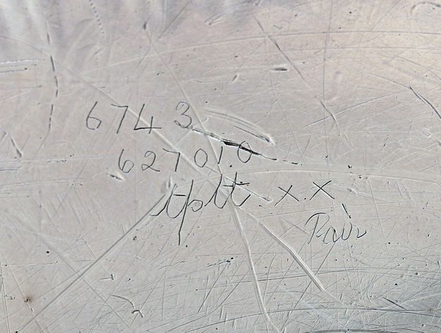 Close-up of the inscription 6743 627010 tplt xx Pair scratched on the stand.