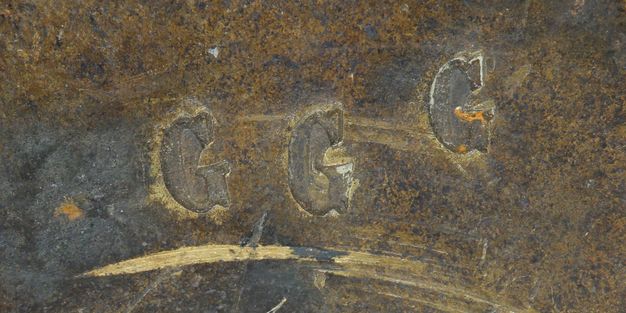 Close-up of the letters G G G stamped side by side on the girandole.