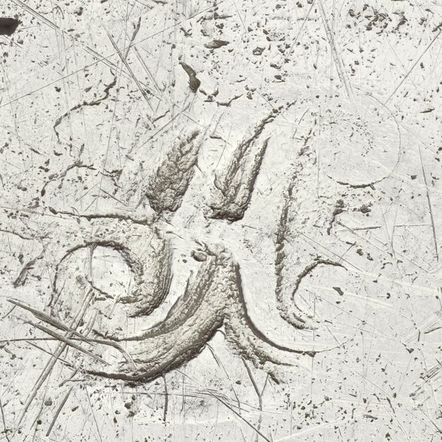 Close-up of a partially stamped A with loops.