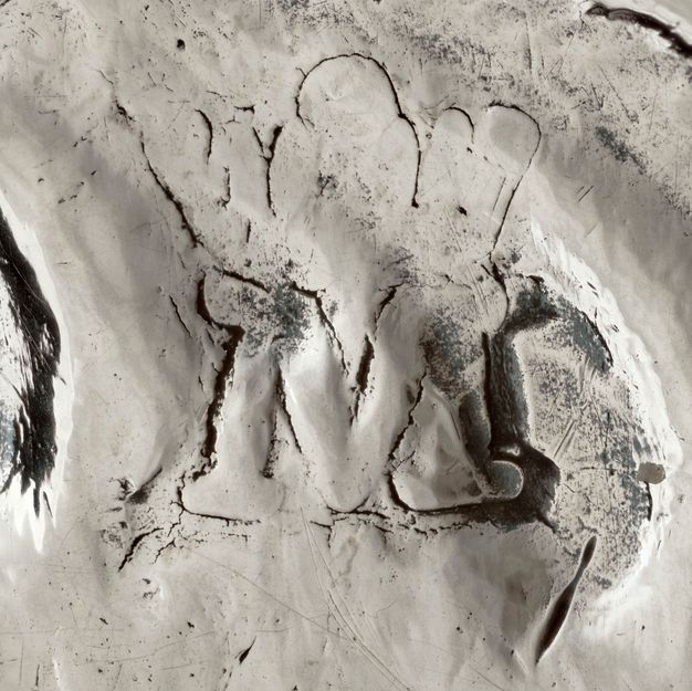 Close-up of a crowned M with serifs stamped on the stand.